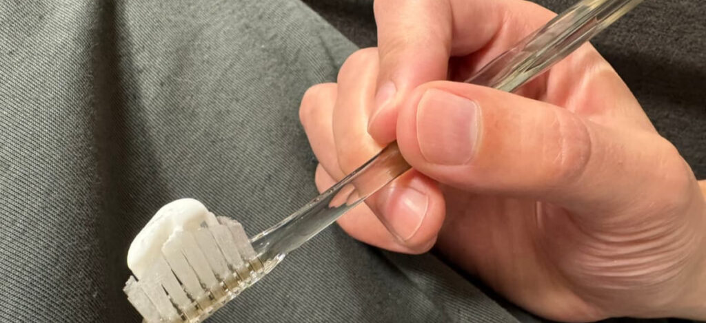 歯磨き粉をつけた奇跡の歯ブラシを夫が手に持っている様子